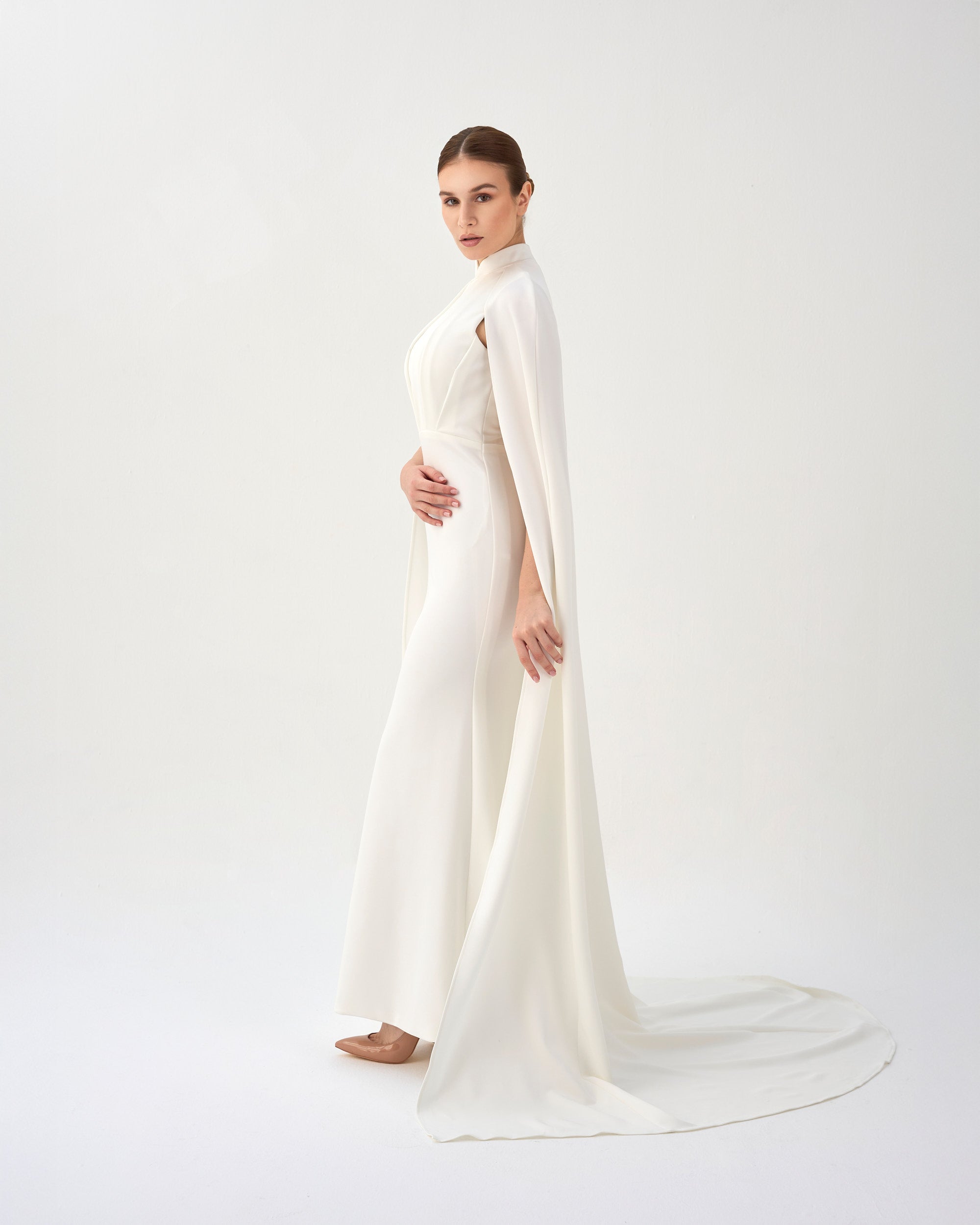 White pleated dress with neckline and cape