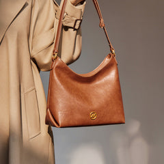 slouchy leather shoulder bag with gold emblem – AURX