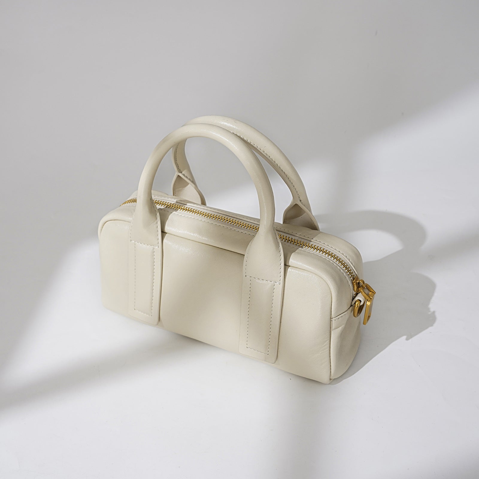 Structured top-handle handbag with bold strap detailing - LUNCA