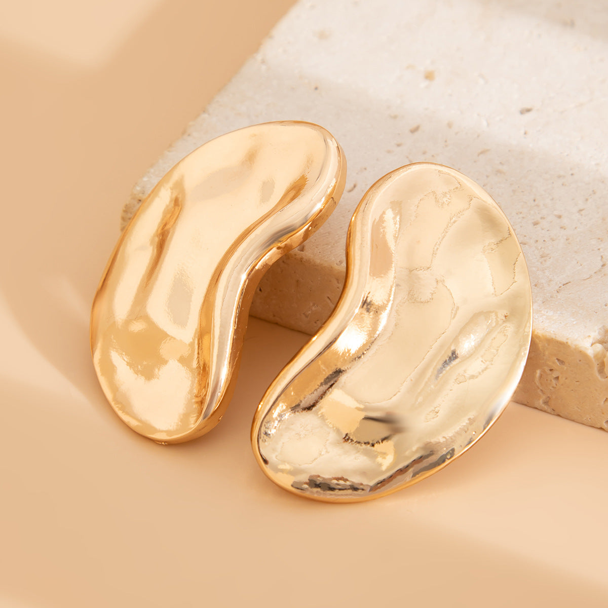 Curved bean-shaped stud earrings in metallic finish - Manbu