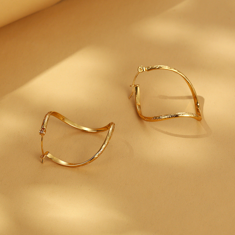 Twisted infinity hoop earrings with engraved detail - Solida