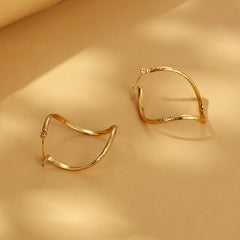 Twisted infinity hoop earrings with engraved detail - Solida