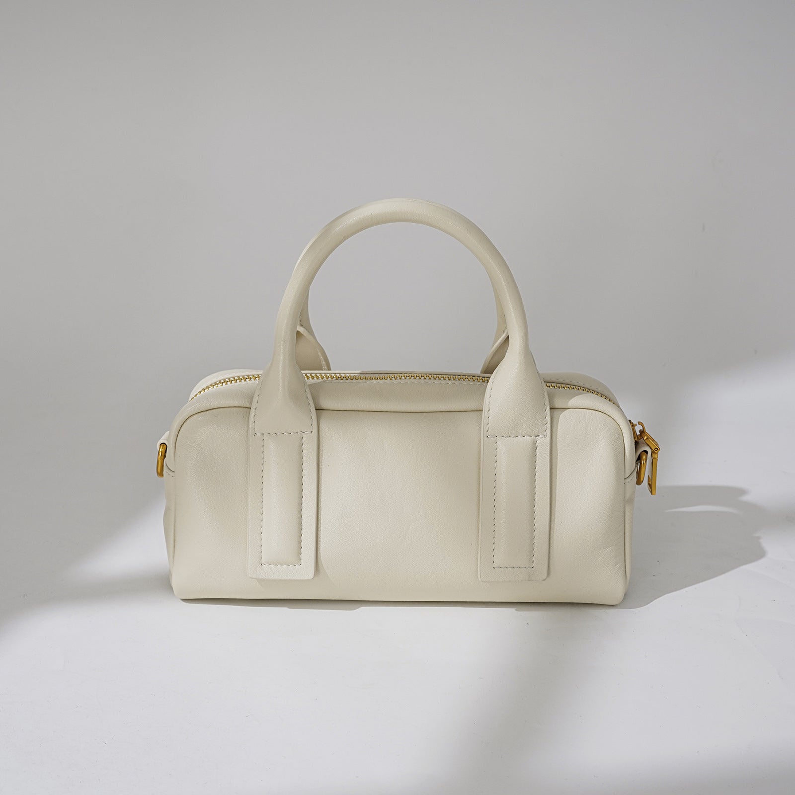structured mini barrel bag in polished black – VERN