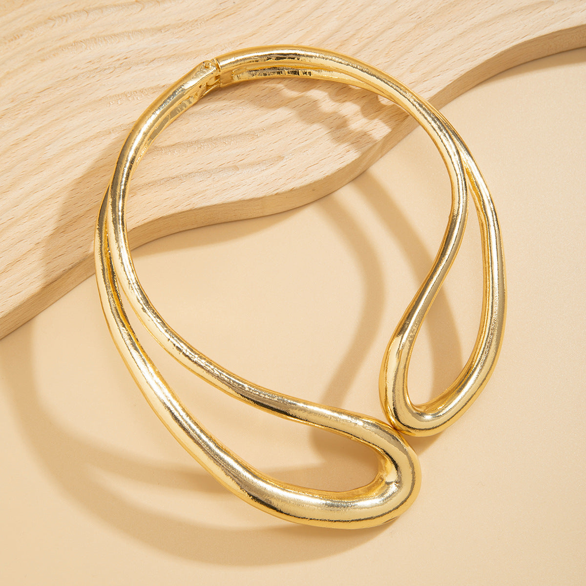 Twisted open metal choker with sculptural wave design - Dolkia