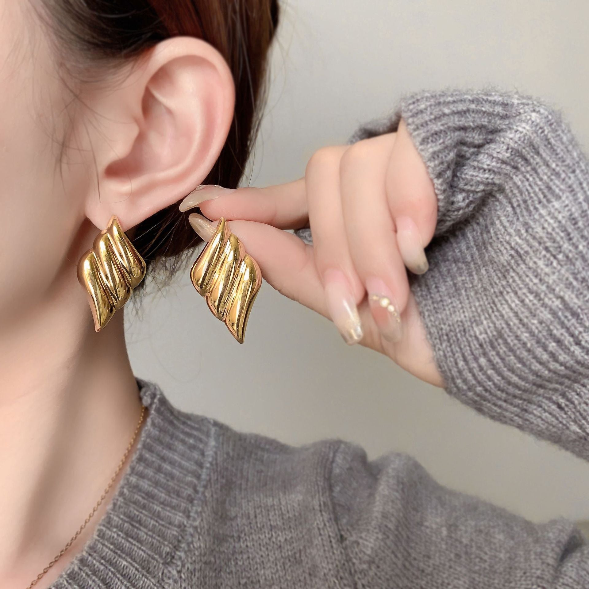 Polished wing-shaped stud earrings with sculpted curves - Ajurti