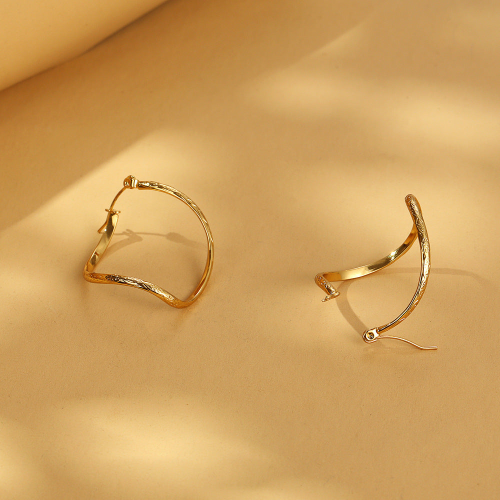 Twisted infinity hoop earrings with engraved detail - Solida