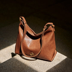 slouchy leather shoulder bag with gold emblem – AURX