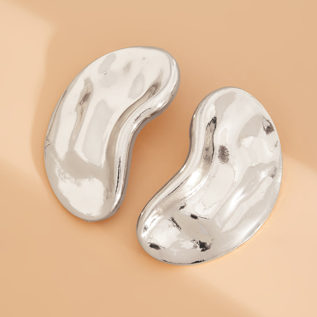 Curved bean-shaped stud earrings in metallic finish - Manbu