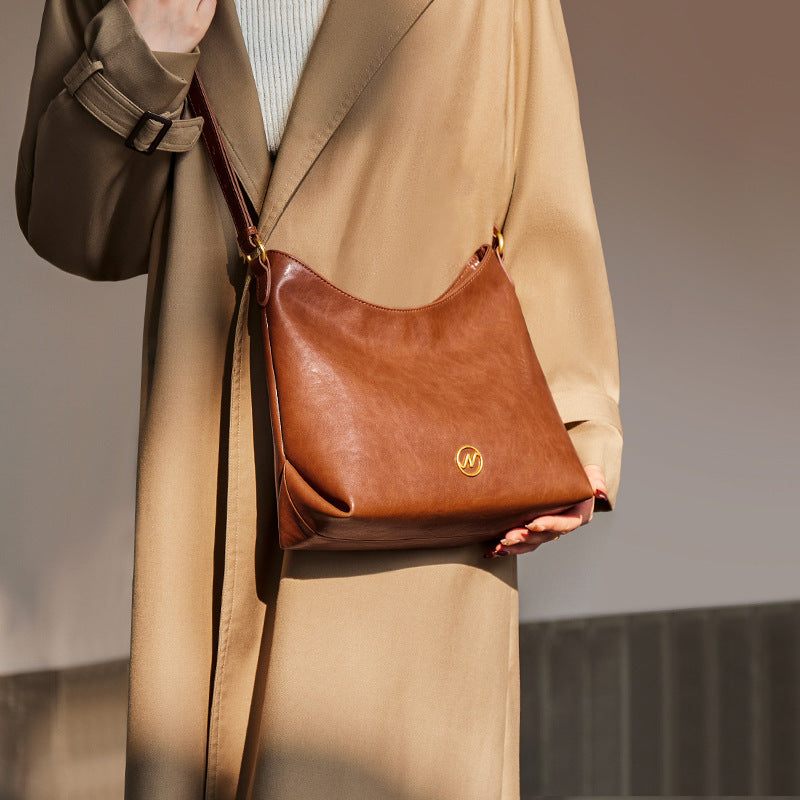 slouchy leather shoulder bag with gold emblem – AURX