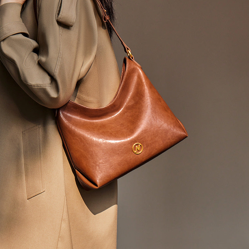 slouchy leather shoulder bag with gold emblem – AURX